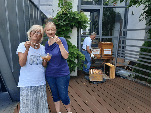 auxilion Mitarbeiterinnen Kerstin Mandara und Marion Stahl genießen den ersten Honig.